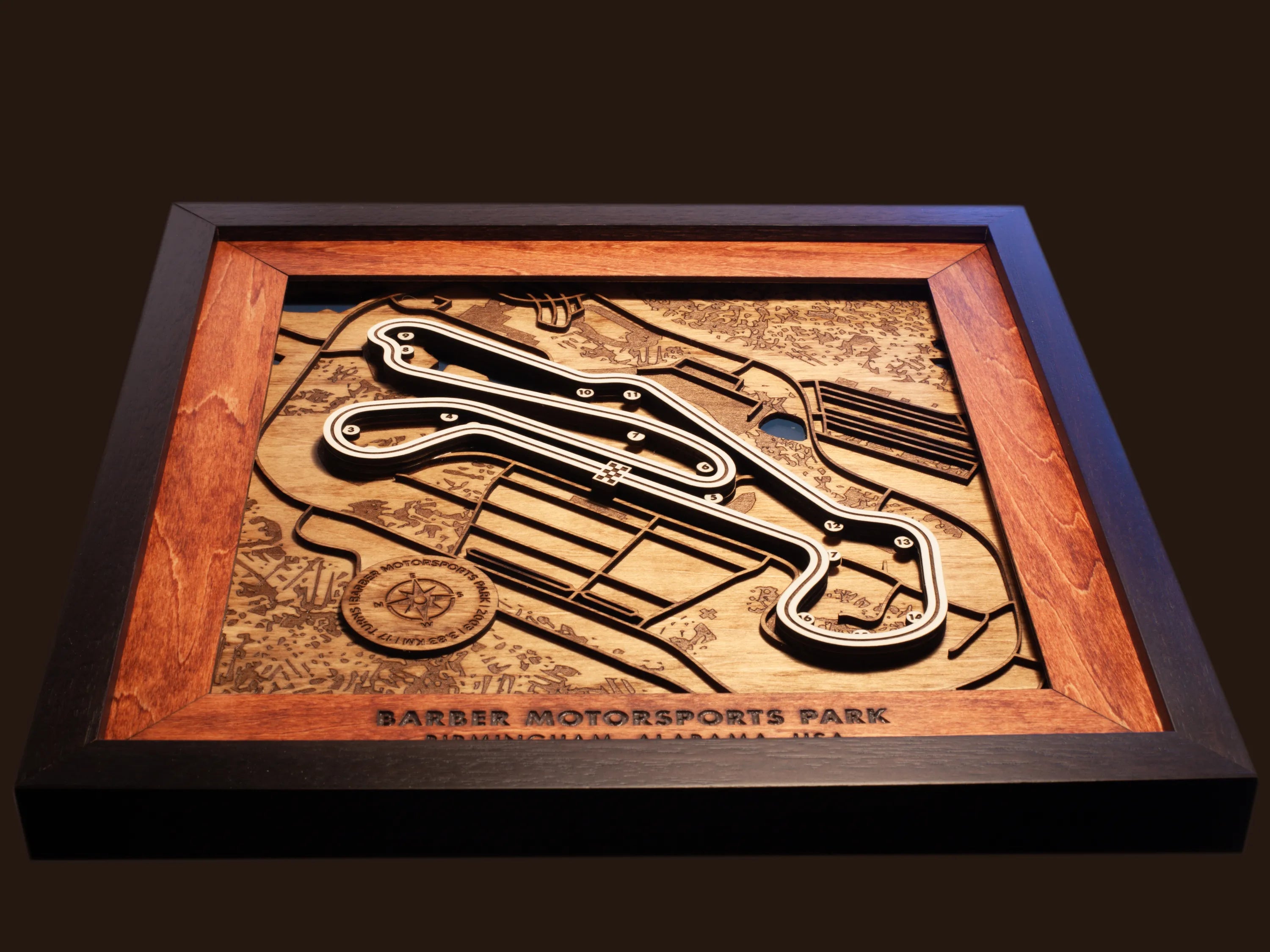 Close-up of the handcrafted layered wood construction and fine details of the Barber Motorsports Park wall art.