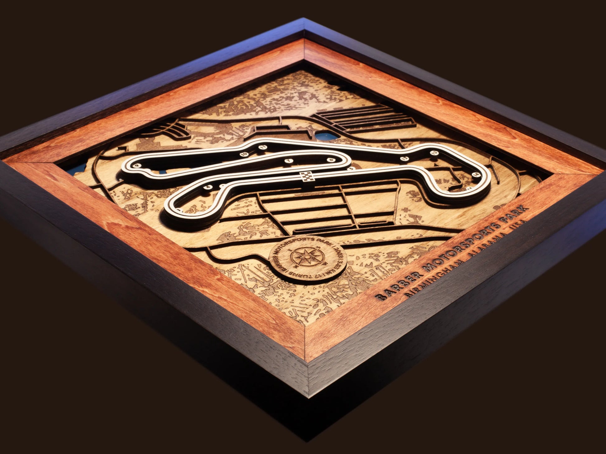 Close-up of the handcrafted layered wood construction and fine details of the Barber Motorsports Park wall art.