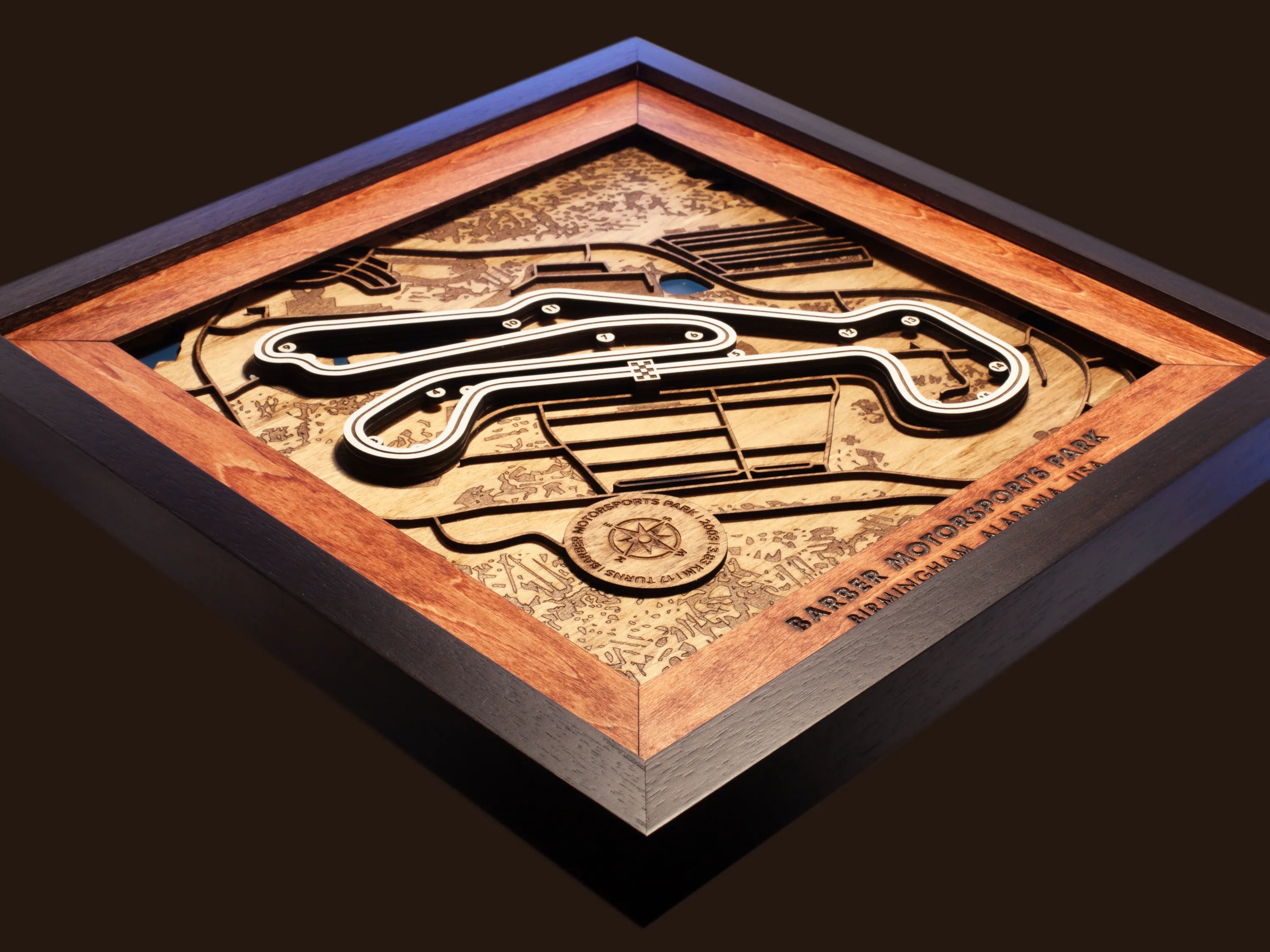 Close-up of the handcrafted layered wood construction and fine details of the Barber Motorsports Park wall art.