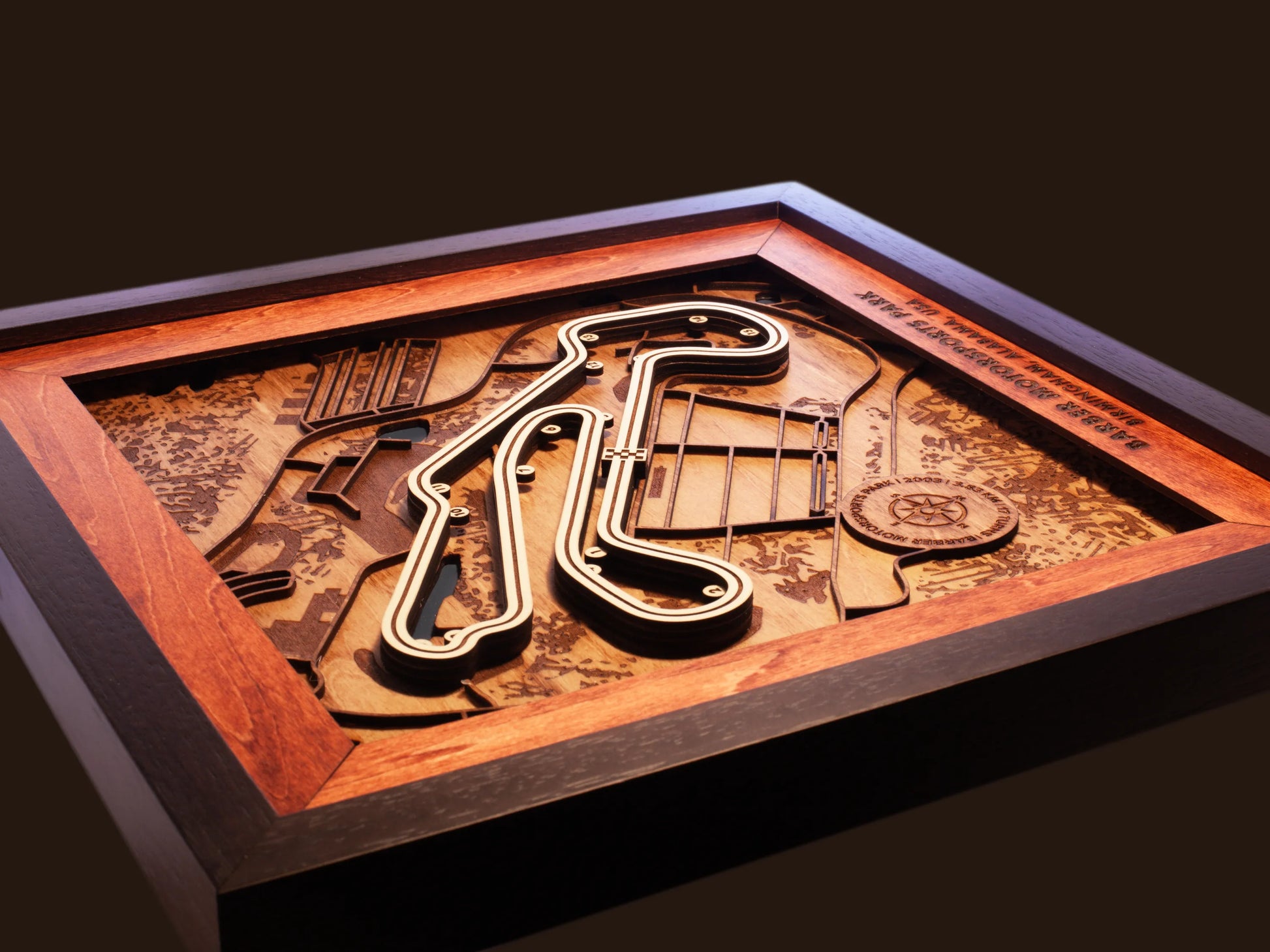 Close-up of the handcrafted layered wood construction and fine details of the Barber Motorsports Park wall art.