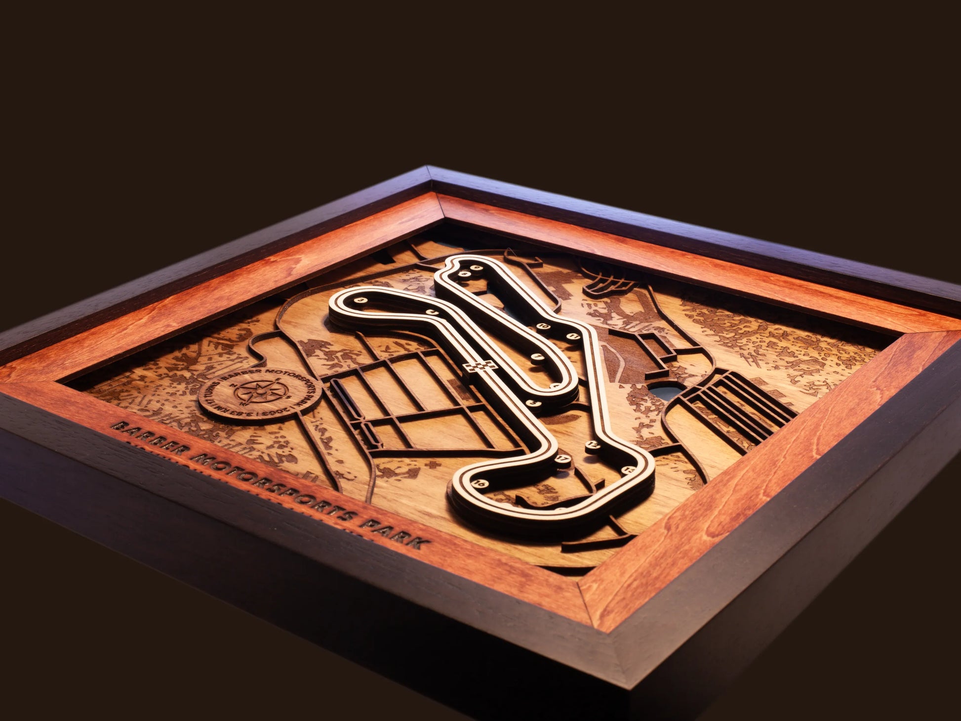 Close-up of the handcrafted layered wood construction and fine details of the Barber Motorsports Park wall art.