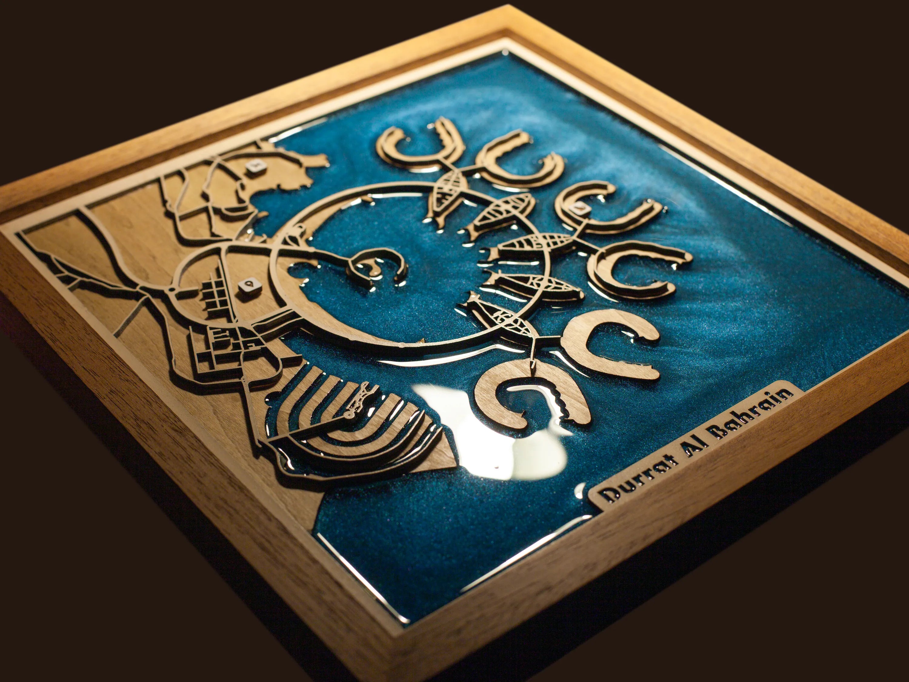 Close-up of the layered wood construction and precision laser engraving of the Durrat Al Bahrain wall art.