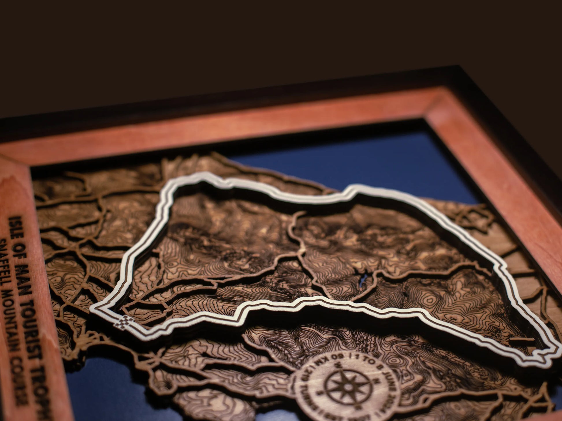 Close-up of the handcrafted layered wood construction and fine details of the Isle of Man TT Course wall art.