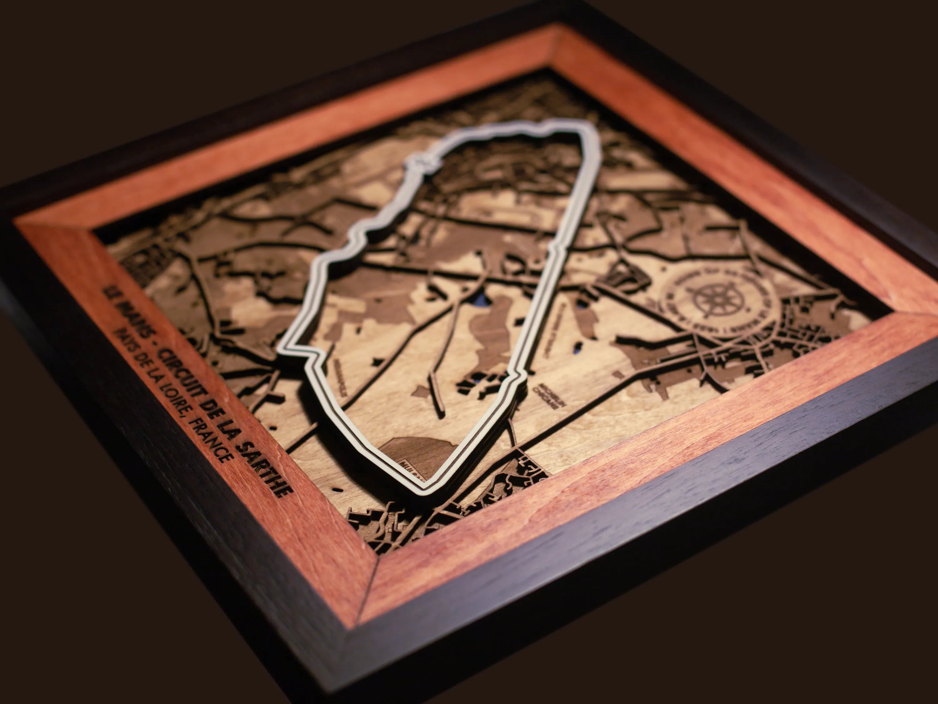 Close-up of the handcrafted layered wood construction and fine details of the Le Mans Circuit wall art.