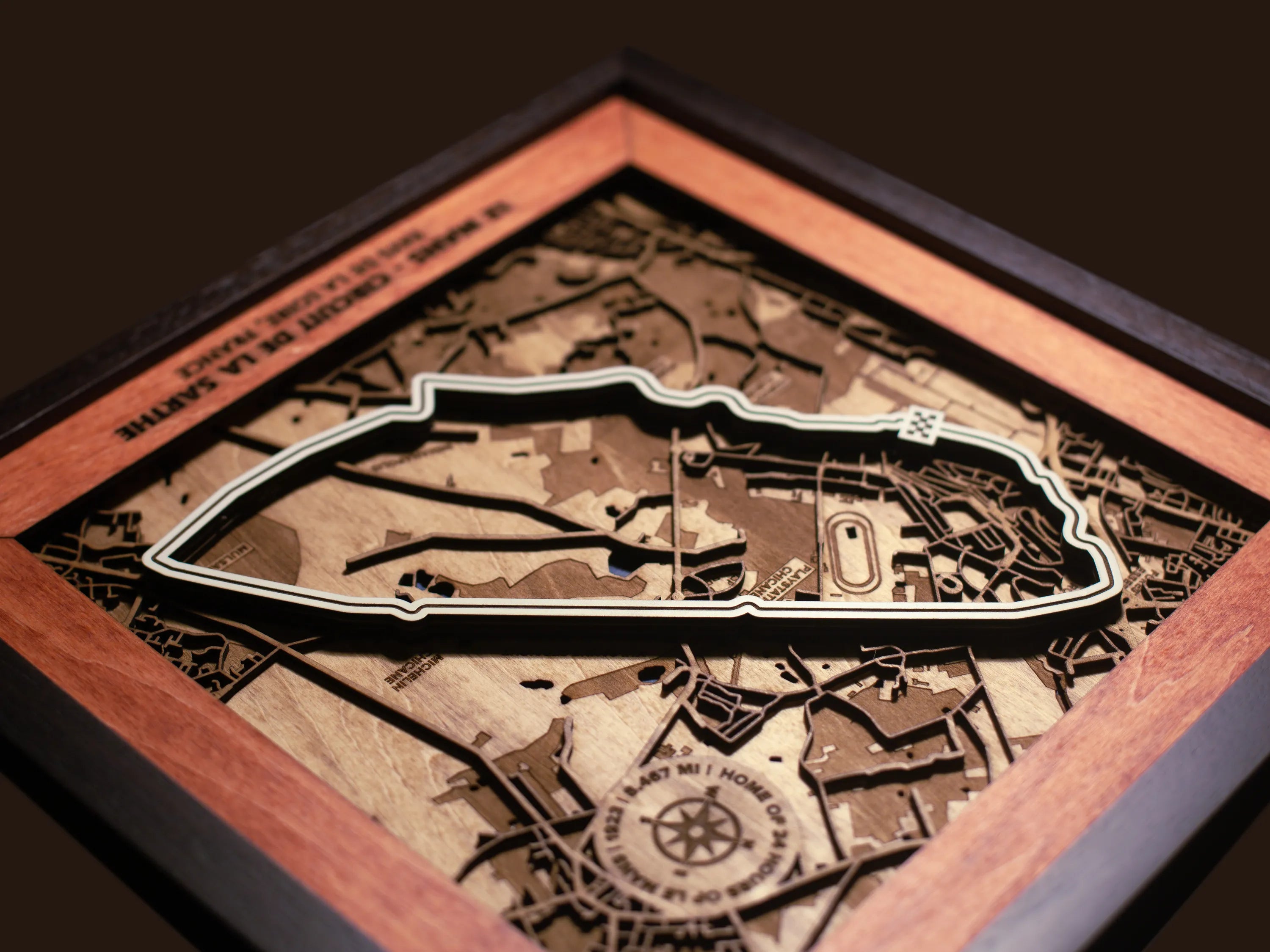 Close-up of the handcrafted layered wood construction and fine details of the Le Mans Circuit wall art.
