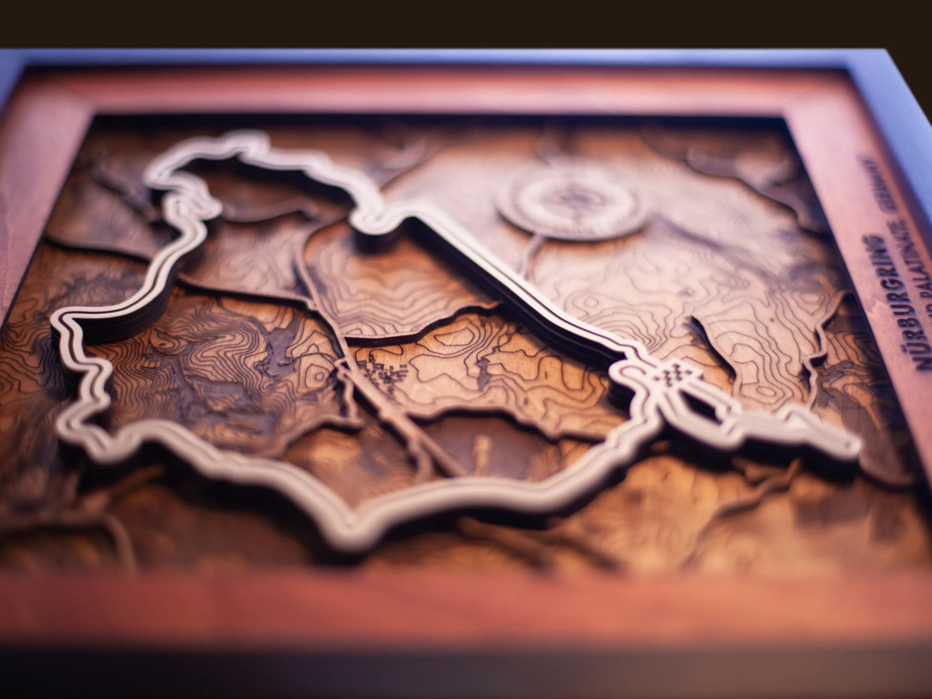 Close-up of the handcrafted layered wood construction and fine details of the NŸrburgring Nordschleife wall art.