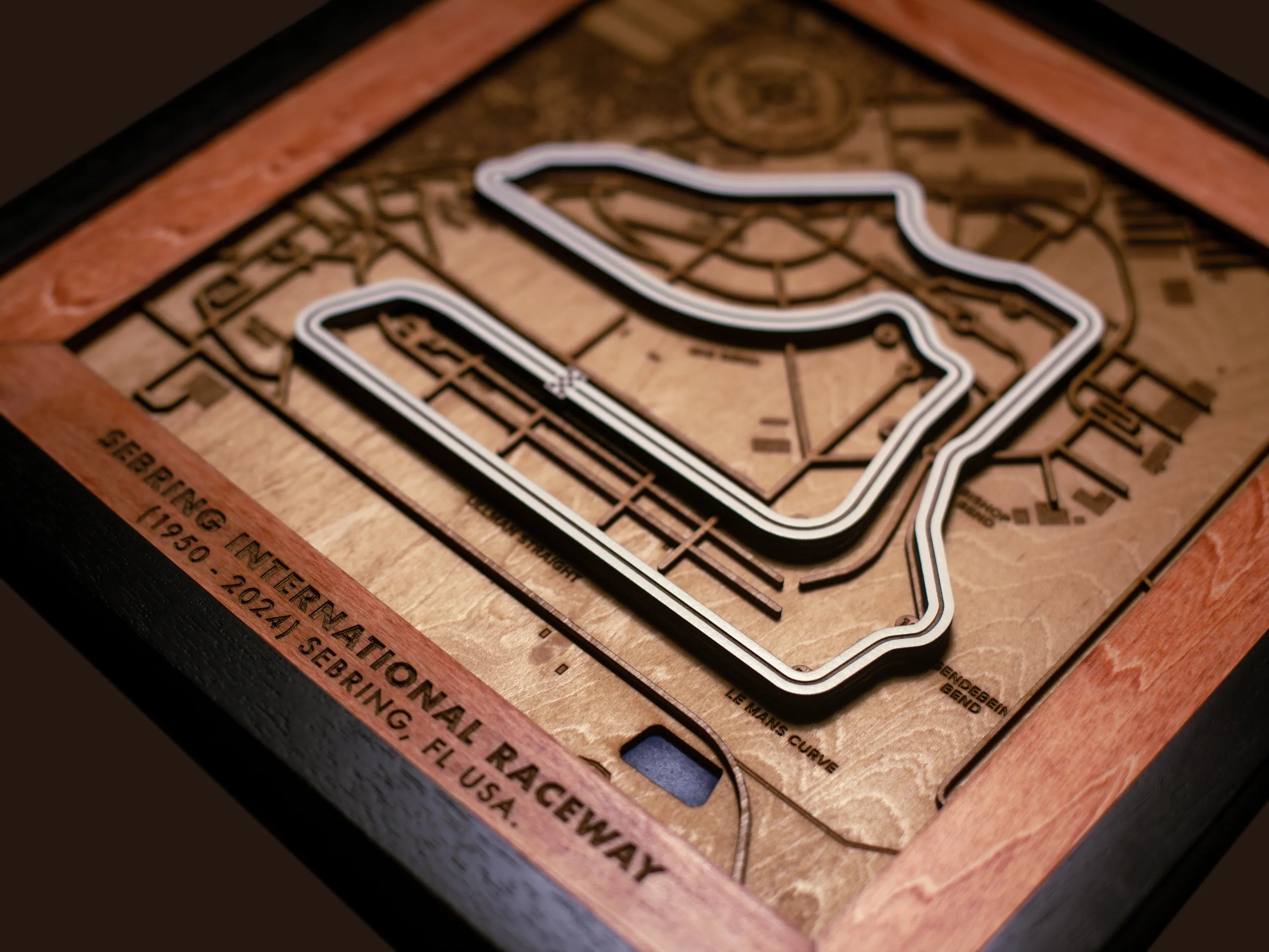 Close-up of the handcrafted layered wood construction and fine details of the Sebring International Raceway wall art.