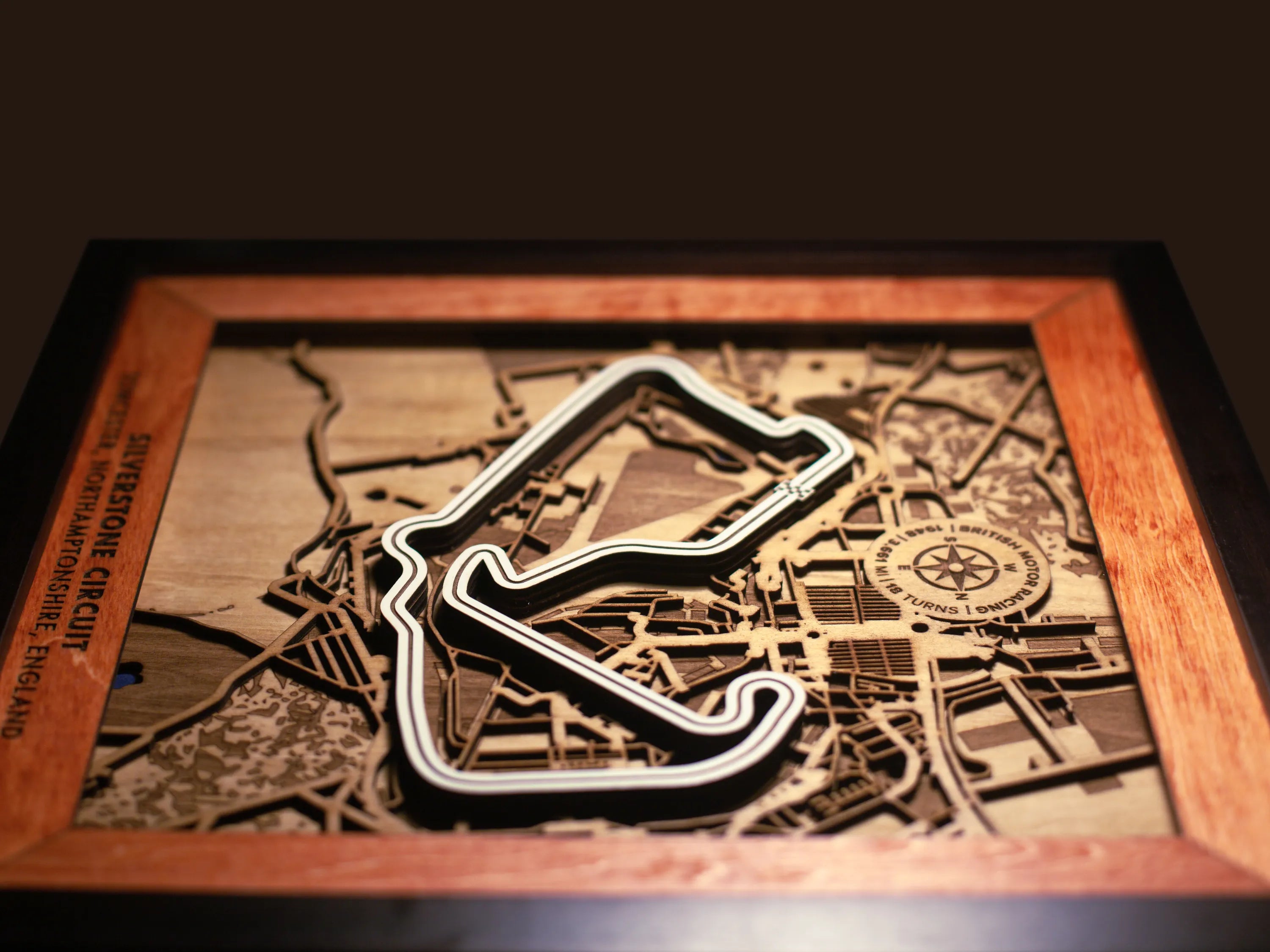 Close-up of the handcrafted layered wood construction and fine details of the Silverstone Circuit wall art.