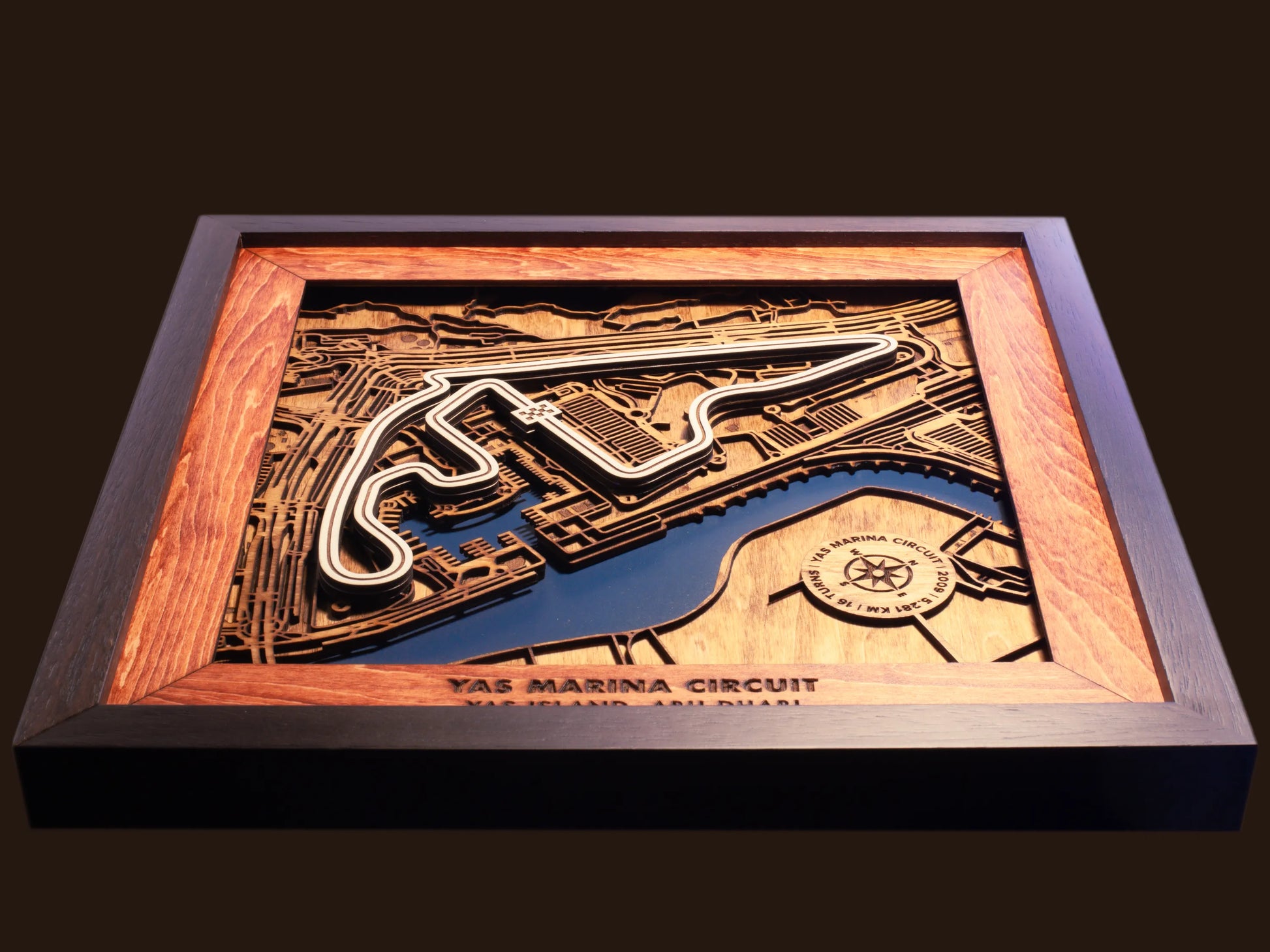 Close-up of the handcrafted layered wood construction and fine details of the Yas Marina Circuit wall art.