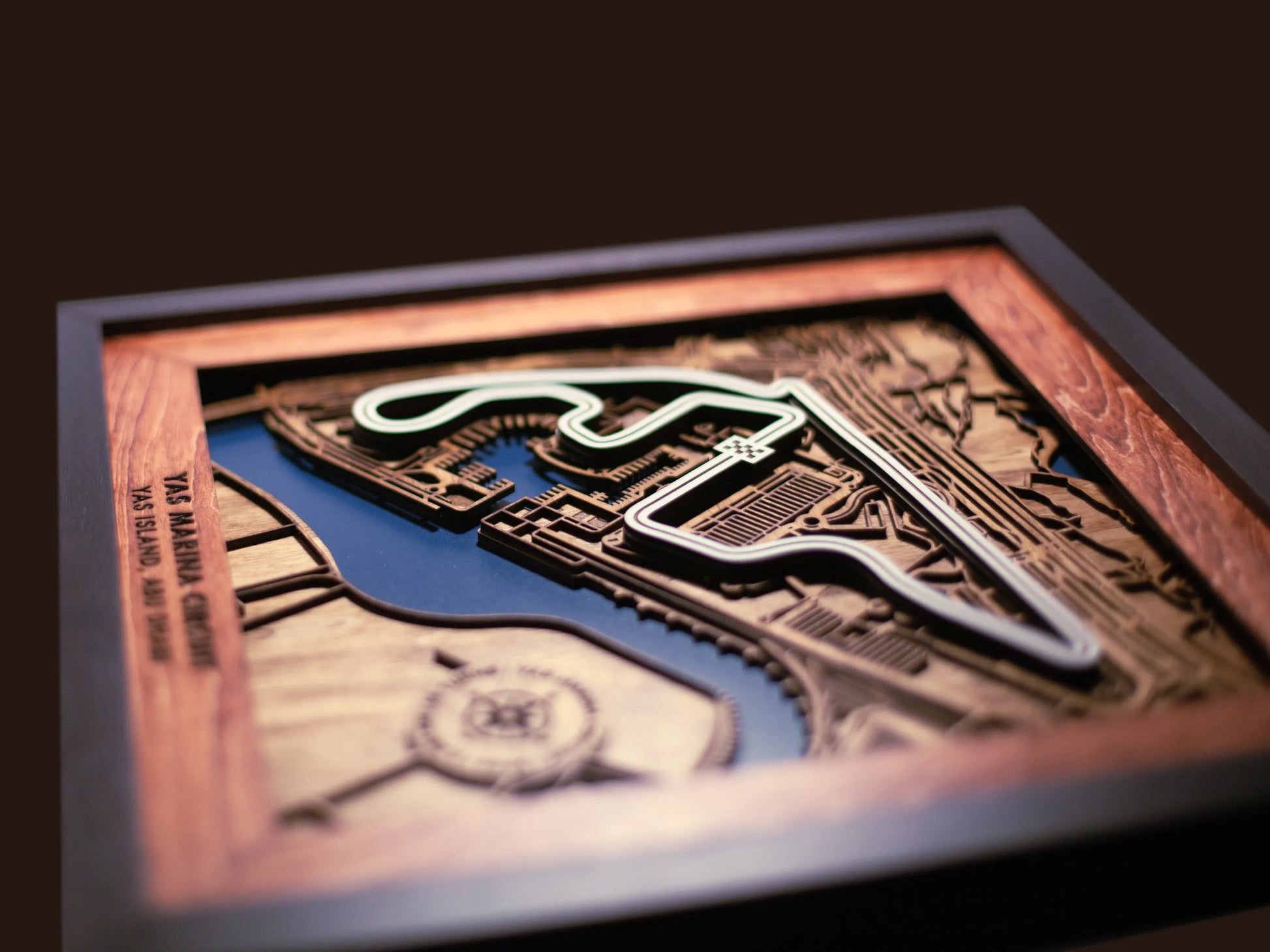 Close-up of the handcrafted layered wood construction and fine details of the Yas Marina Circuit wall art.